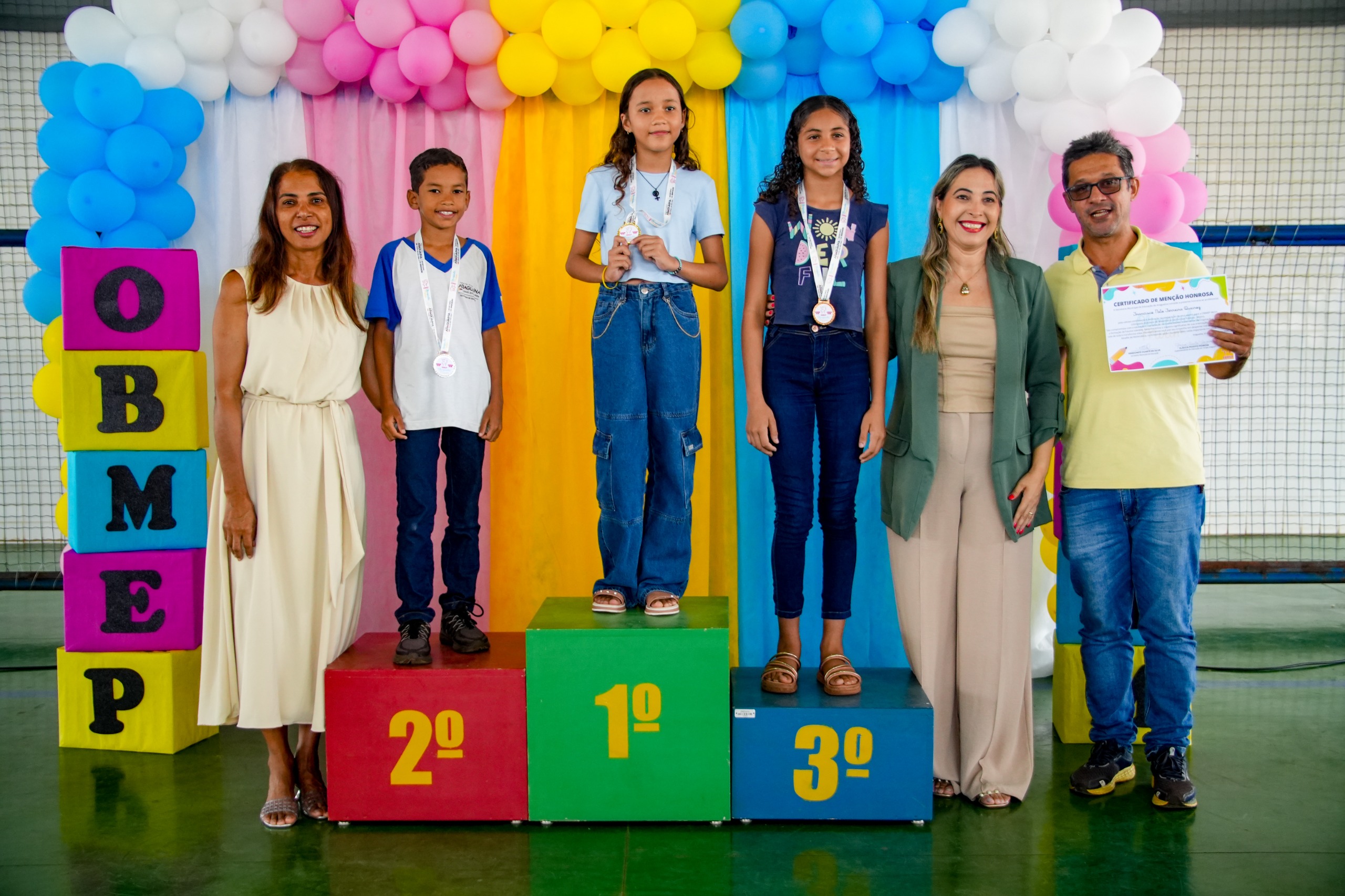“Fico muito feliz porque é a segunda vez que ganho. A prova da OBMEP faz a gente pensar bastante, porque tem muitas questões de raciocínio lógico.” Contou a medalhista Maria Flor( ao centro da foto).